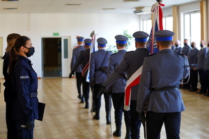 Poczet sztandarowy opuszcza salę uroczystości. Obok stoją policjanci w szeregu