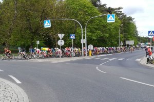 Peleton kolarzy przejeżdża przez jedno ze skrzyżowań w Grudziądzu