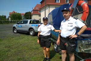 Policjanci przy pojeździe przed wyjazdem do służby