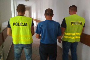 włamywacz i policjanci przed doprowadzeniem do sądu