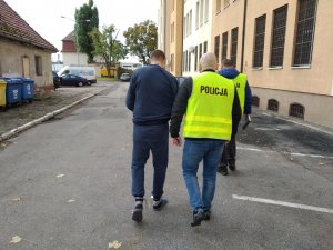 policjanci doprowadzają zatrzymanego