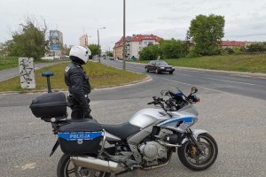 Policjant ruchu drogowego stojący obok motocykla