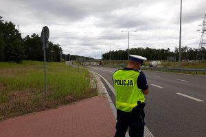 Policjant mierzący prędkość i prowadzący kontrole drogowe.