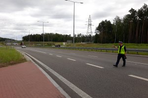 Policjant mierzący prędkość i prowadzący kontrole drogowe.