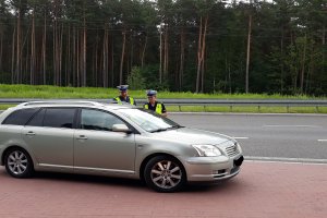 Policjant mierzący prędkość i prowadzący kontrole drogowe.