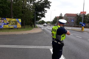 Policjant mierzący prędkość i prowadzący kontrole drogowe.