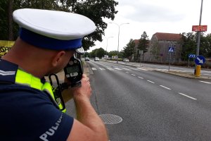 Policjant mierzący prędkość i prowadzący kontrole drogowe.