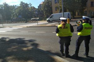 Dwie policjantki na podczas pomiaru prędkości ręcznym miernikiem.