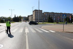 Policjant dokonuje pomiarów na miejscu wypadku.