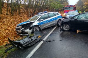 Na jezdni stoi uszkodzony citroen, a na poboczu rozbity radiowóz