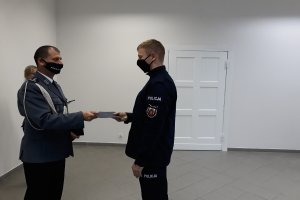 Policjant odbiera akt mianowania z rąk komendanta