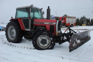 Ciągnik rolniczy w dali widać stojący wóz strażacki