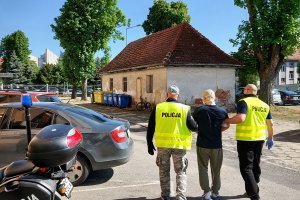 Policjanci prowadzą zatrzymanego