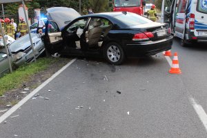 Dwa rozbite pojazdy. Obok pojazdów służby ratunkowe