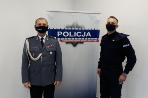 Dwóch policjantów na tle baneru Policja