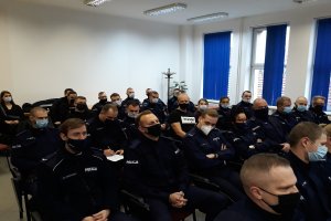 Grupa policjantów siedzi na sali