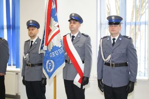 poczet sztandarowy, trzech policjantów stoi ze sztandarem