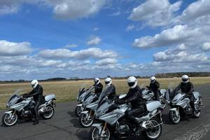 na zdjęciu widać grupę policjantów siedzących na motocyklach, na głowach mają założone kaski.