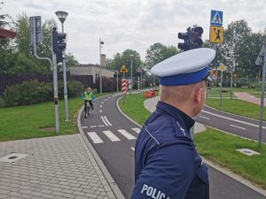 Policjant z dziećmi w miasteczku ruchu drogowego