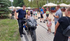 policjant prezentuje dziecku motocykl policyjny