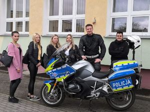 policjant z uczniami przy motocyklu służbowym