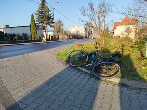 uszkodzony rower leżący na chodniku