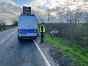 policjant przy pojeździe w rowie i ambulansie pogotowia wypadkowego