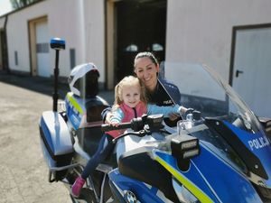 policjantka z dzieckiem na motocyklu służbowym