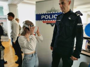 policjant z gościem targów w trakcie pokazu gogli VR