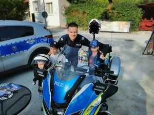 policjant z dziećmi przy motocyklu