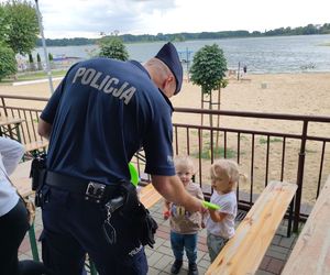 policjant z dziećmi na plaży