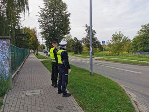 Policjant ze strażnikiem miejskim przy szkole