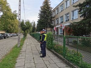 Policjant ze strażnikiem miejskim przy szkole