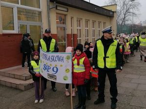 policjanci z dziećmi w trakcie przemarszu przez miasto