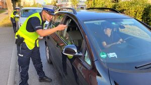 policjanci wręczający ulotki kierowcom