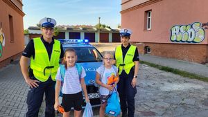 policjanci z uczniami przy radiowozie