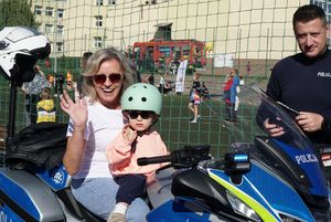 uczestnicy festynu na motocyklu w towarzystwie policjanta