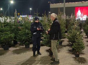 policjantka kontrolująca punkt sprzedaży choinek