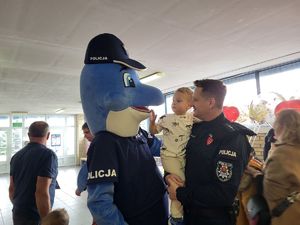 policjant z dzieckiem na ręku przy polfinie