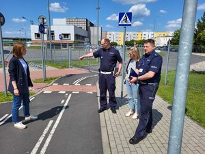 policjanci z kierownikiem WORD-u w trakcie obchodu miasteczka ruchu drogowego