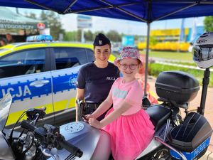 dziewczynka na motocyklu policyjnym w towarzystwie policjantki