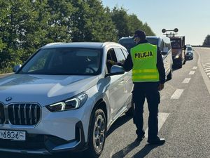 policjant badający kierowcę na zawartość alkoholu