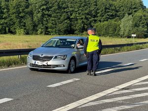 policjanci badający kierowcę na zawartość alkoholu