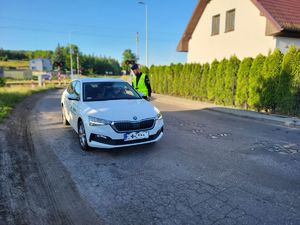 policjant badający kierowcę na zawartość alkoholu