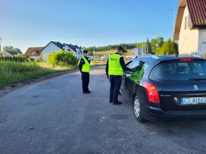 policjant badający kierowcę na zawartość alkoholu