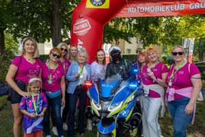 policjant na motocyklu z uczestnikami biegu
