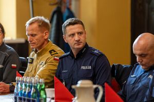 policjanci i strażak przy stole w refektarzu urzędu miejskiego