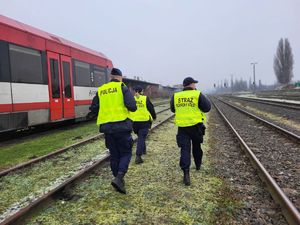 policjant ze strażnikami ochrony kolei na torowisku