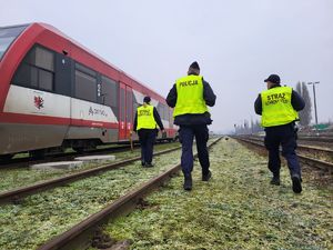 policjant ze strażnikami ochrony kolei na torowisku