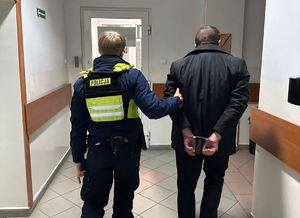 policjant doprowadzający zatrzymanego do PDOZ